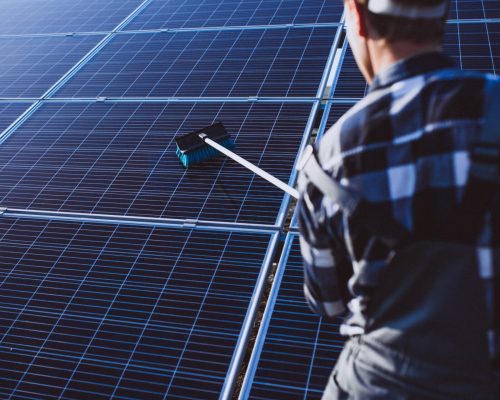 Man worker in the firld by the solar panels